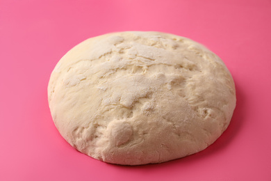 Photo of Raw dough for pastries on pink background, closeup