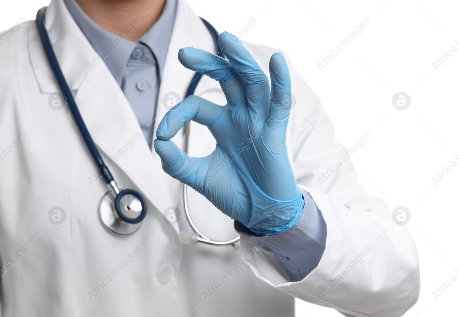 Photo of Doctor wearing light blue medical gloves showing ok gesture on white background, closeup