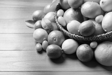Image of Different citrus fruits on wooden table. Black and white tone 