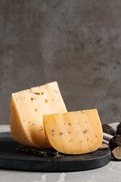 Photo of Fresh cheese and truffles on grey table