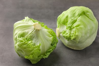 Fresh green iceberg lettuce heads on grey textured table, closeup