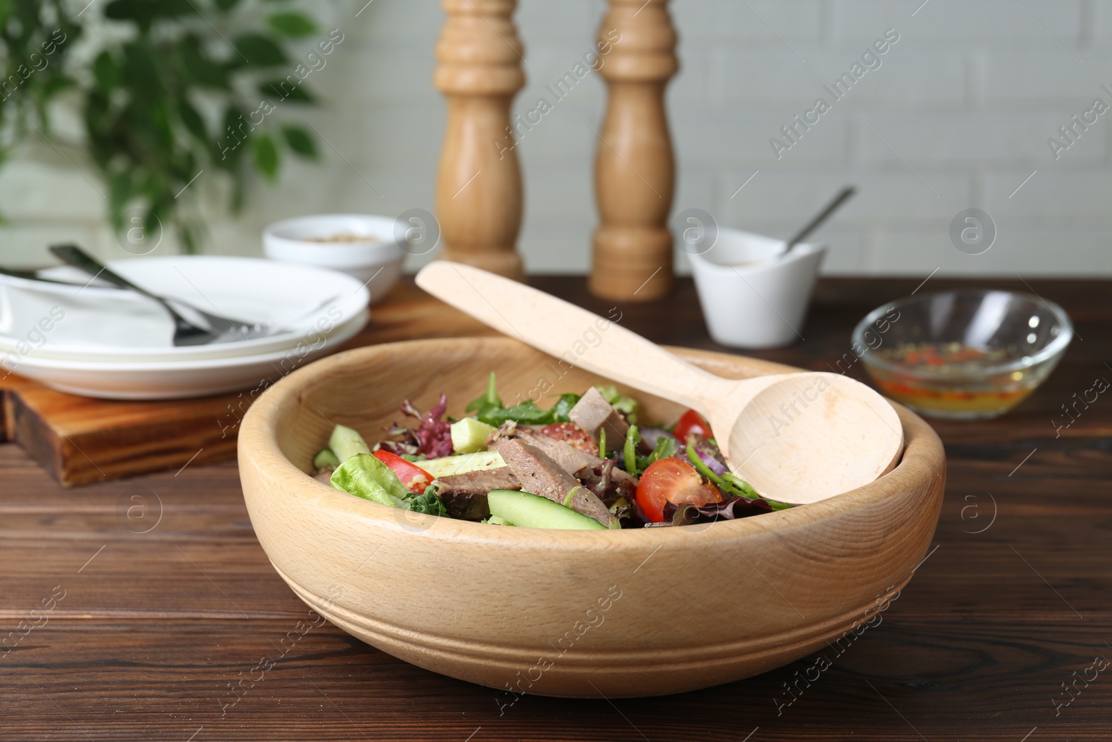 Photo of Delicious salad with beef tongue, vegetables and spoon served on wooden table