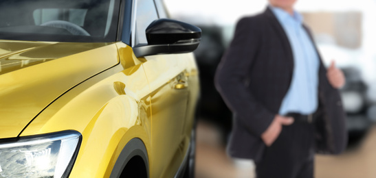 Image of Customer choosing and buying car in auto dealership, focus on new auto. Banner design
