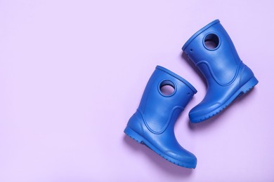 Photo of Pair of blue rubber boots on light background top view. Space for text
