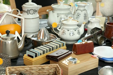 Photo of Many different stuff on black wooden table. Garage sale