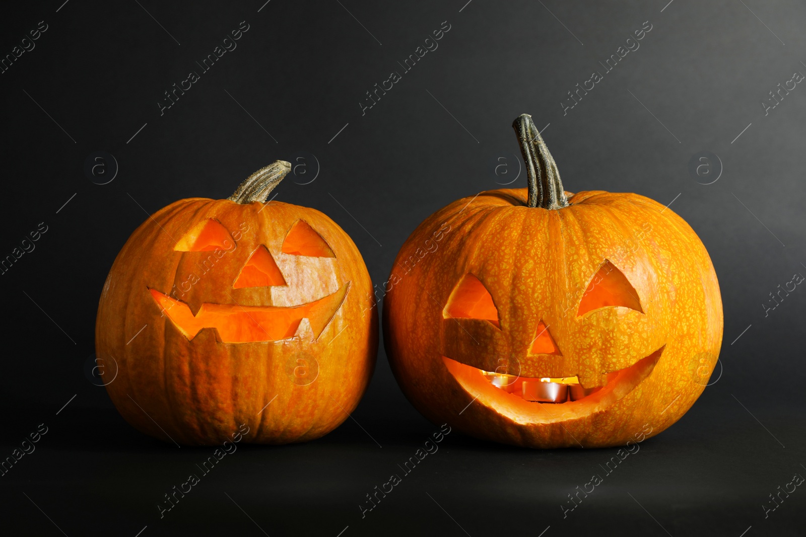 Photo of Halloween pumpkin head jack lanterns on dark background