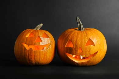 Photo of Halloween pumpkin head jack lanterns on dark background