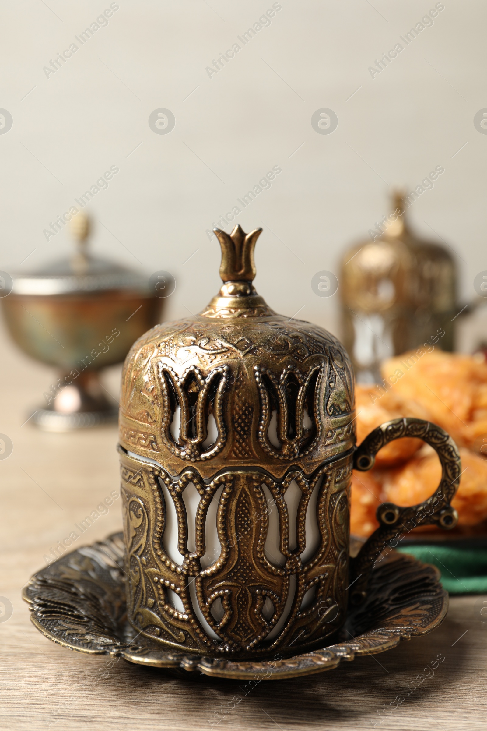 Photo of Tea and baklava dessert served in vintage tea set on wooden table, closeup