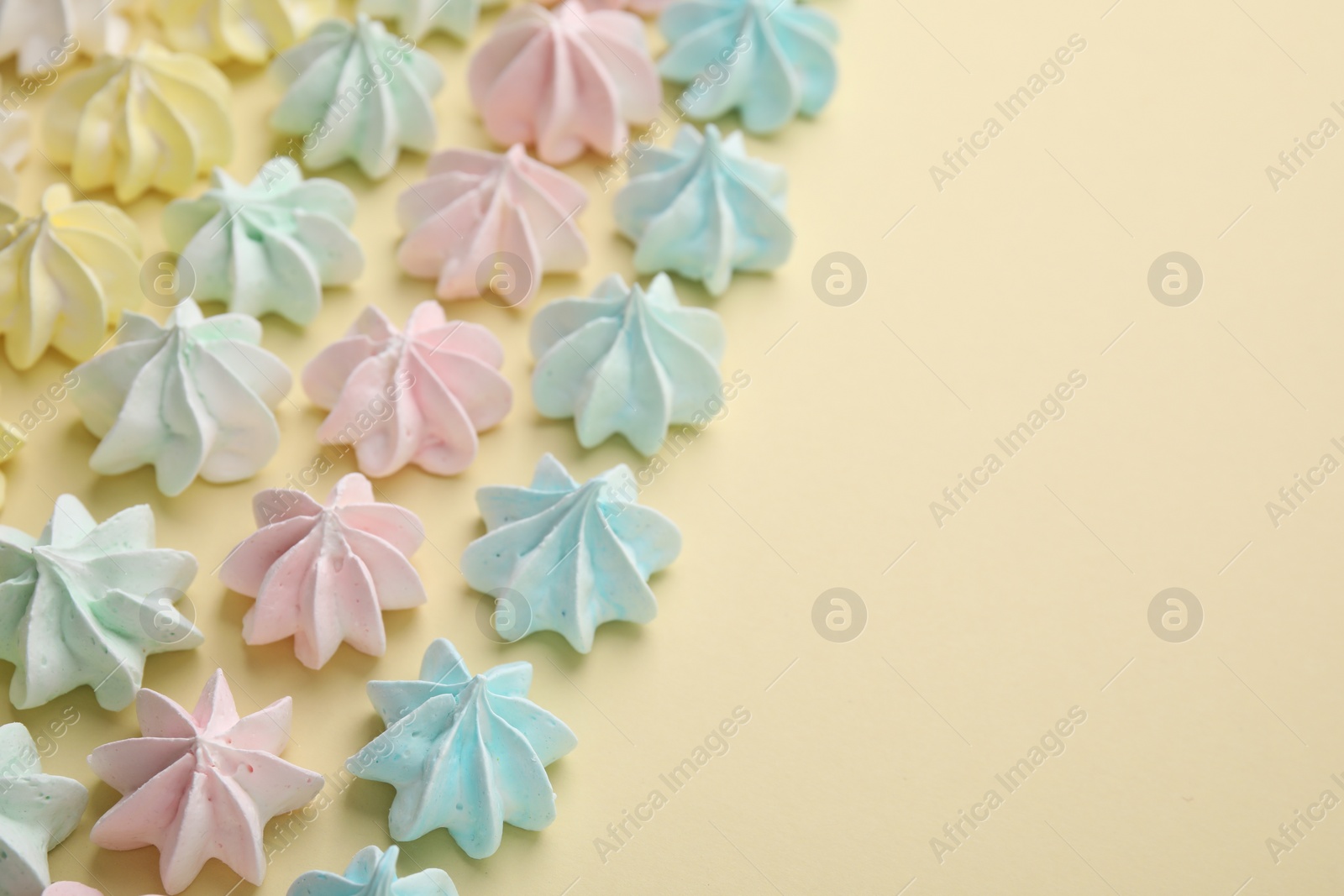 Photo of Delicious meringue cookies on beige background, closeup. Space for text