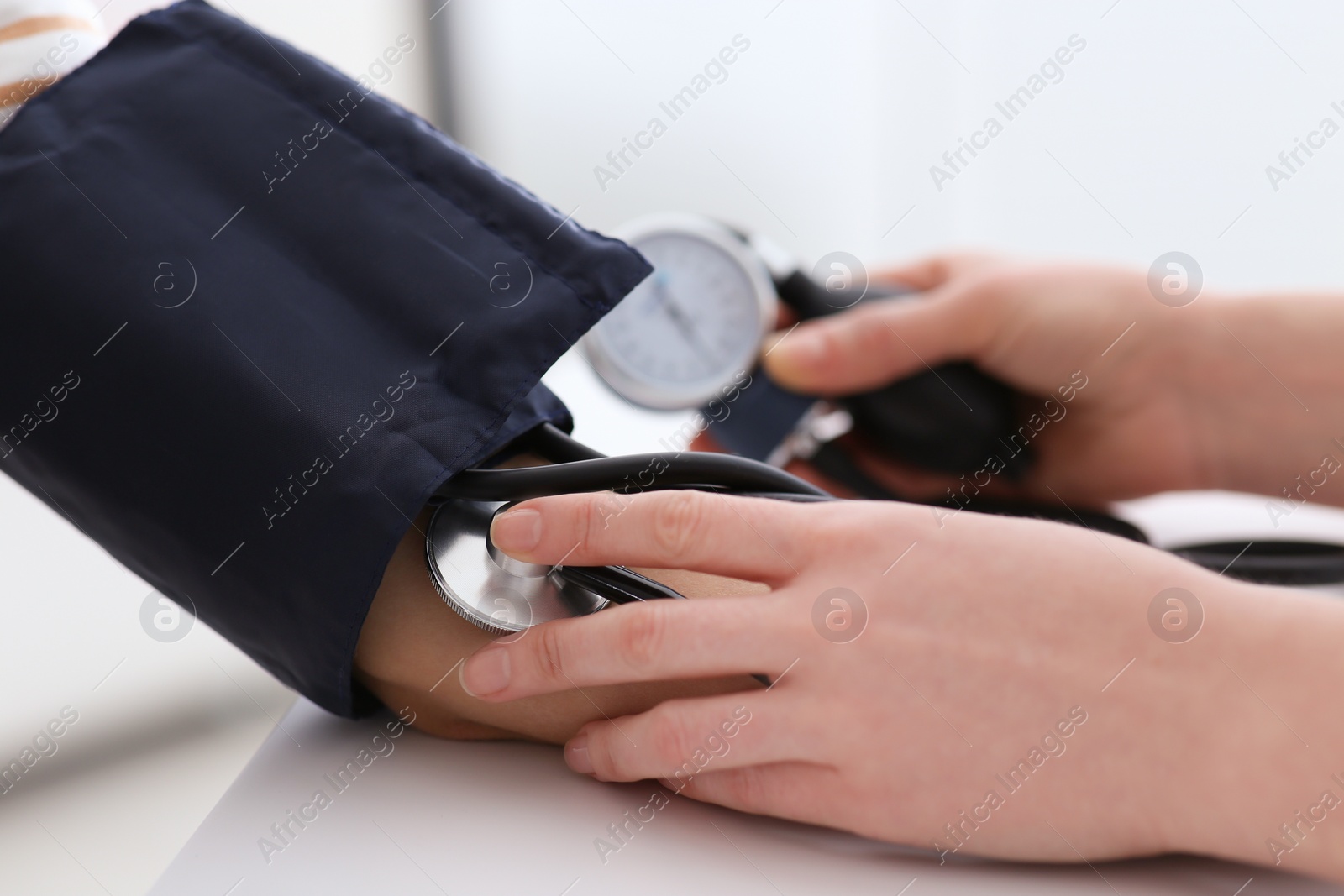 Photo of Doctor checking blood pressure of woman in clinic, closeup