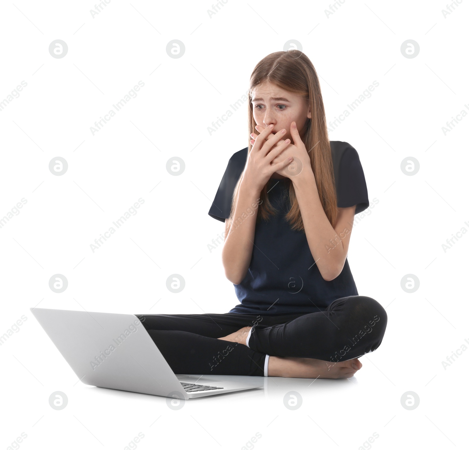 Photo of Shocked teenage girl with laptop on white background. Danger of internet