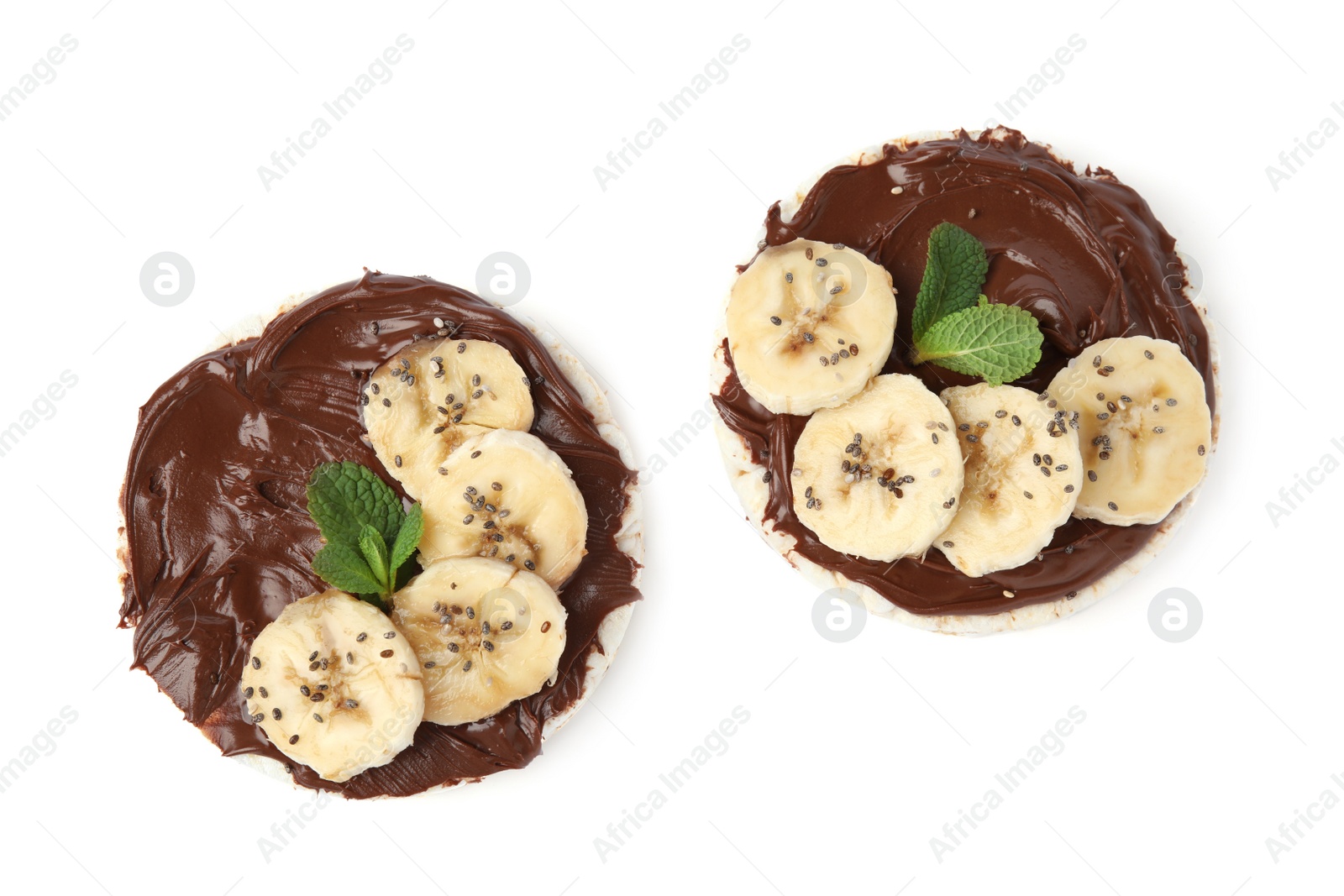 Photo of Puffed rice cakes with chocolate spread, banana and mint isolated on white, top view