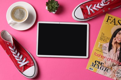 Photo of Online store. Tablet, sneakers, coffee, magazine and houseplant on pink background, flat lay