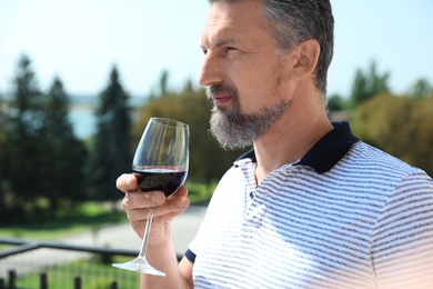 Photo of Man with glass of red wine outdoors