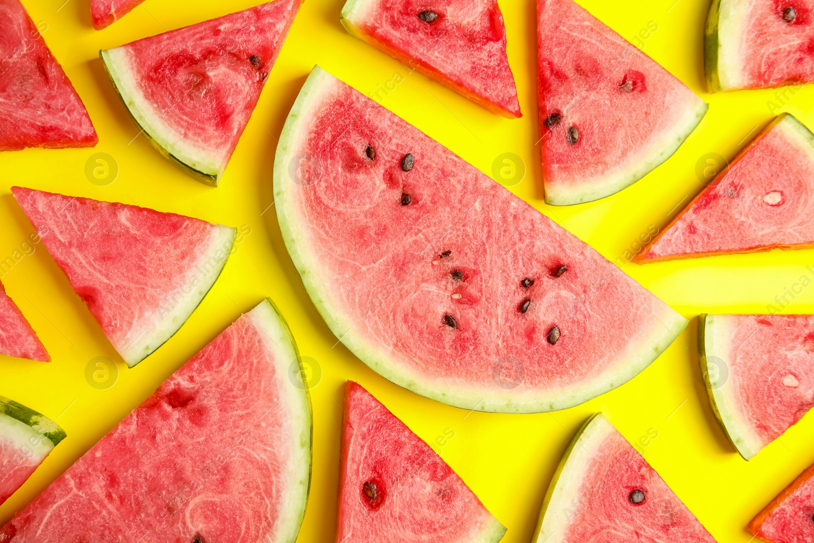 Photo of Slices of ripe watermelon on yellow background, flat lay