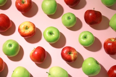 Many different ripe apples on pink background, flat lay