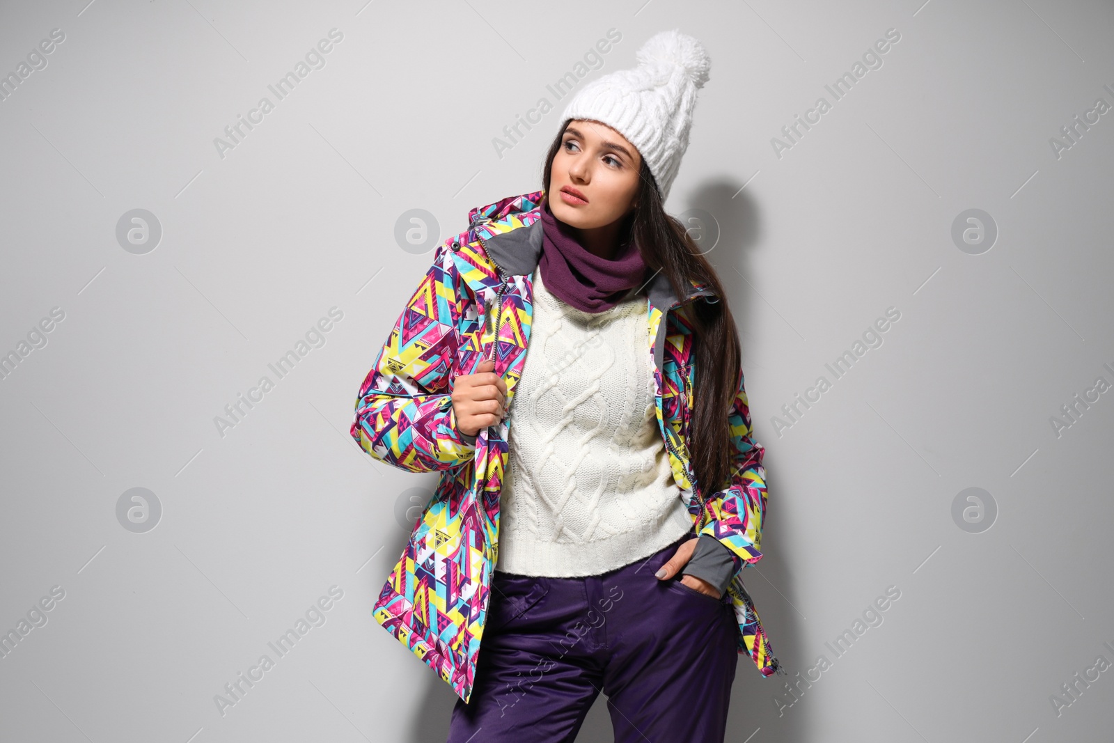 Photo of Woman wearing stylish winter sport clothes on light grey background