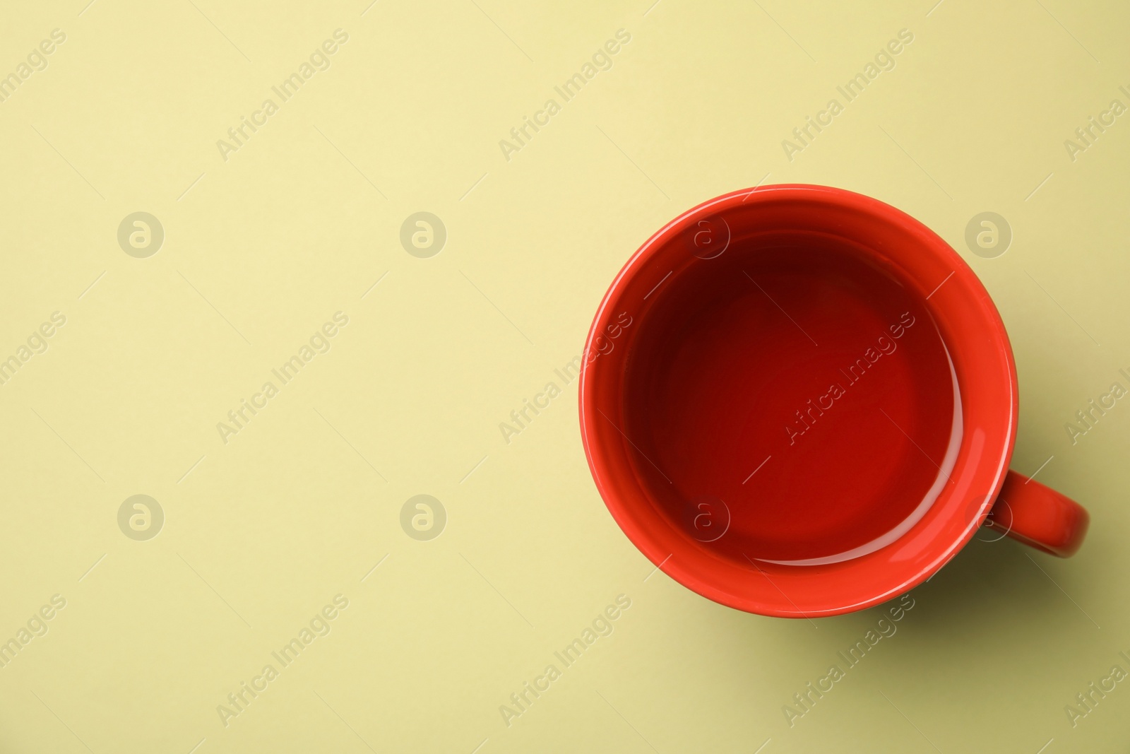 Photo of Cup of black tea on color background, top view