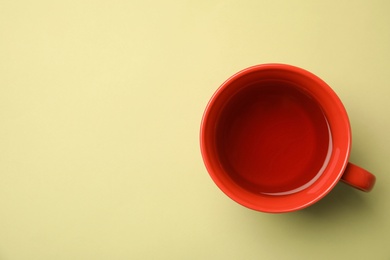 Photo of Cup of black tea on color background, top view