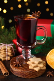 Photo of Christmas composition with aromatic mulled wine on wooden table, closeup
