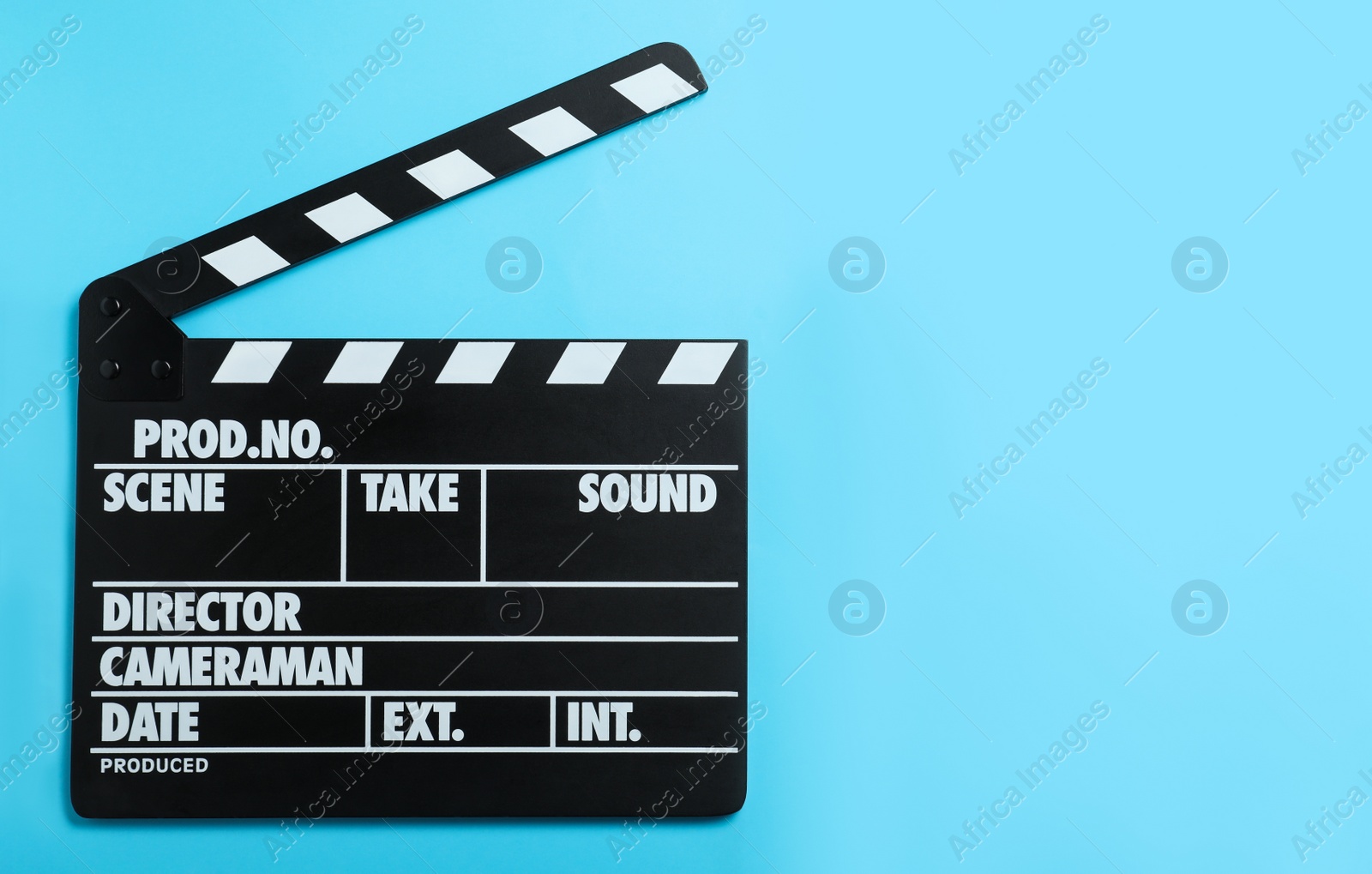 Photo of Clapper board on light blue background, top view with space for text. Cinema production