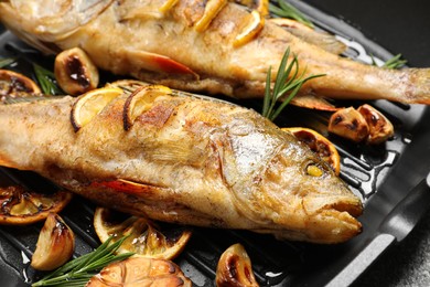 Photo of Tasty homemade roasted perches on grill pan, closeup. River fish