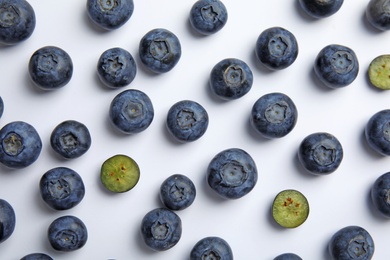 Photo of Tasty ripe blueberries on white background, flat lay