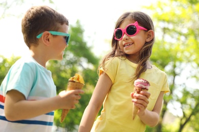 Photo of Cute little children with delicious ice creams outdoors