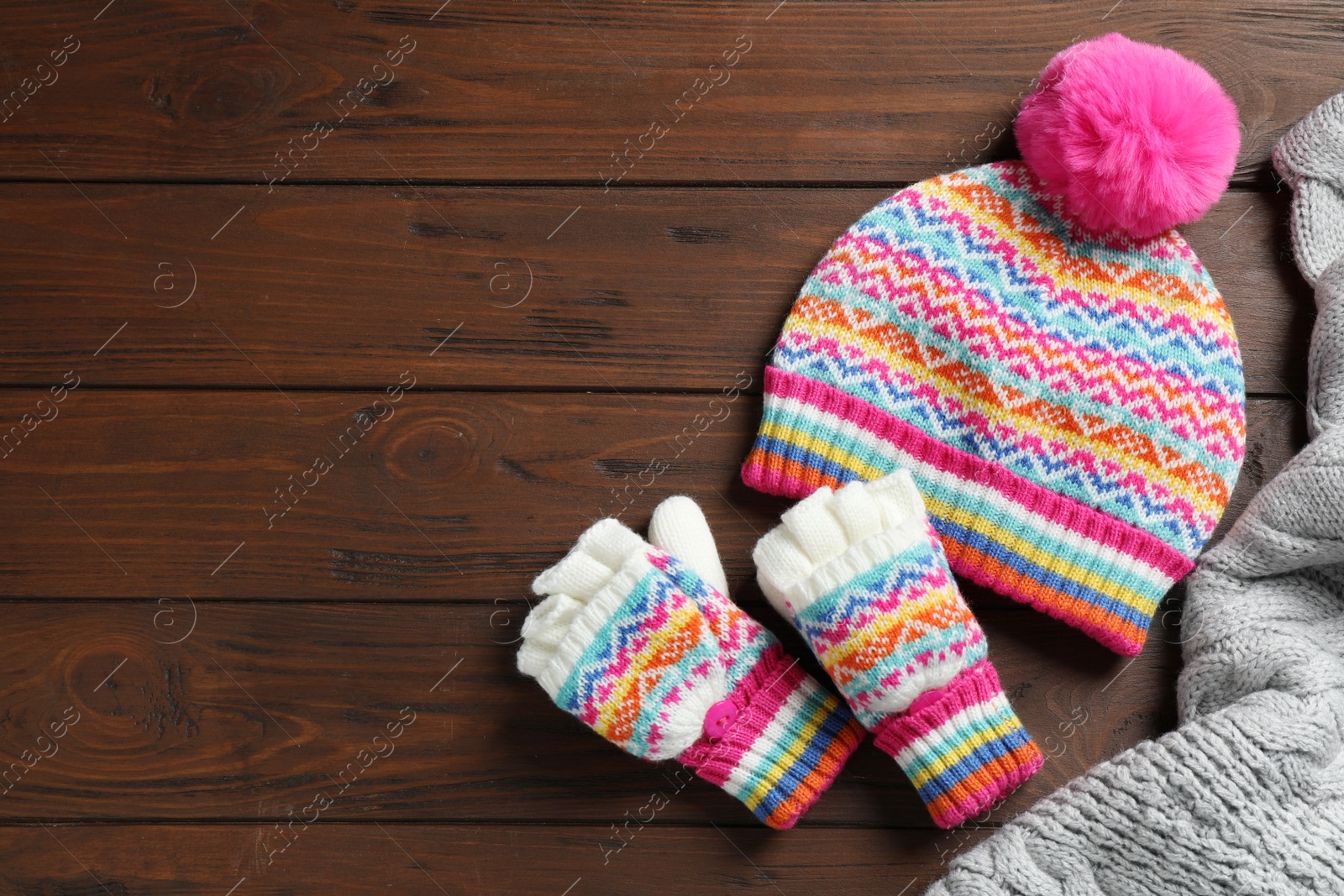 Photo of Warm knitted clothes on wooden background, flat lay. Space for text
