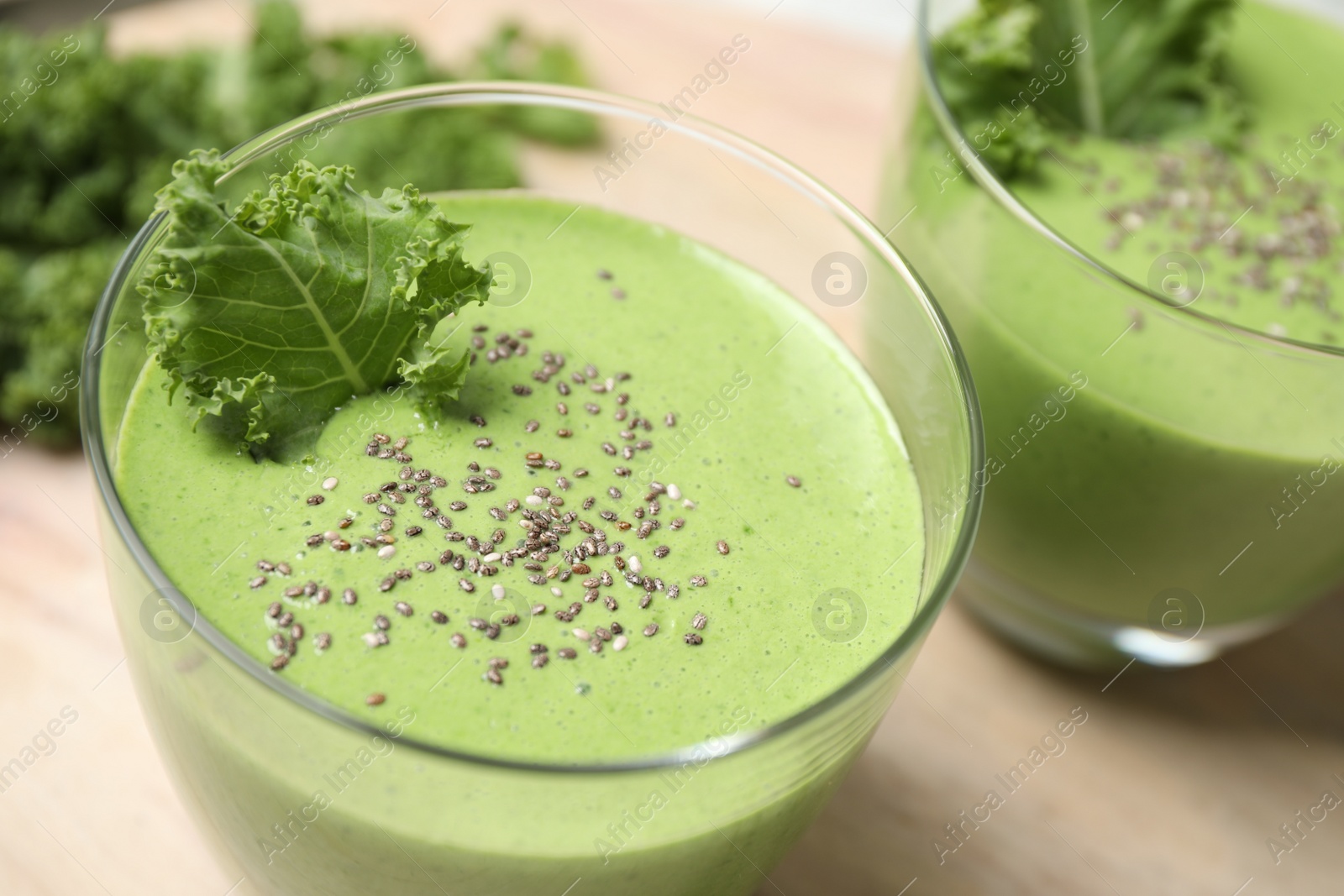 Photo of Tasty kale smoothie with chia seeds on wooden table, closeup