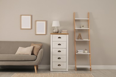 Photo of Modern room interior with chest of drawers near light wall