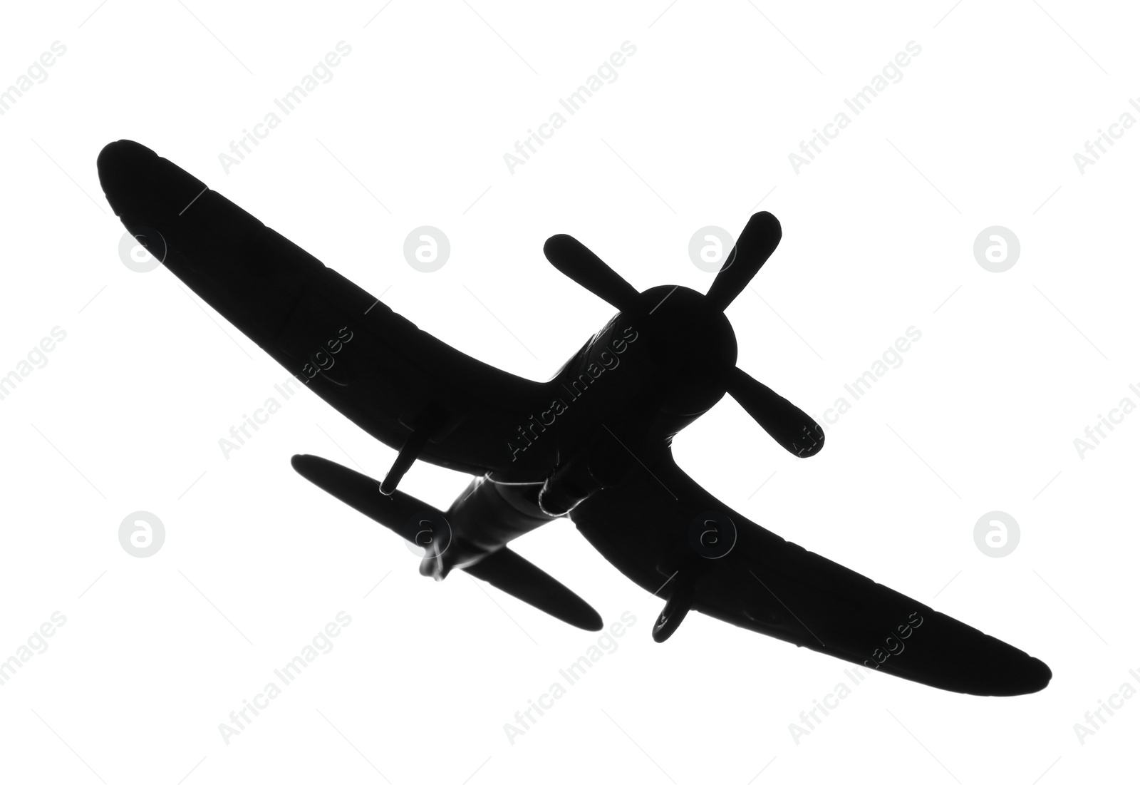 Photo of Dark silhouette of vintage toy military airplane on white background