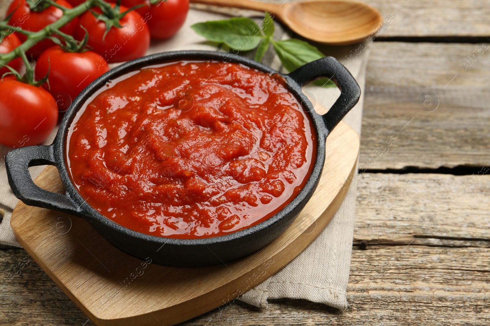 Photo of Homemade tomato sauce in bowl on wooden table, closeup