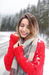 Young woman in warm clothes outdoors on snowy day. Winter vacation