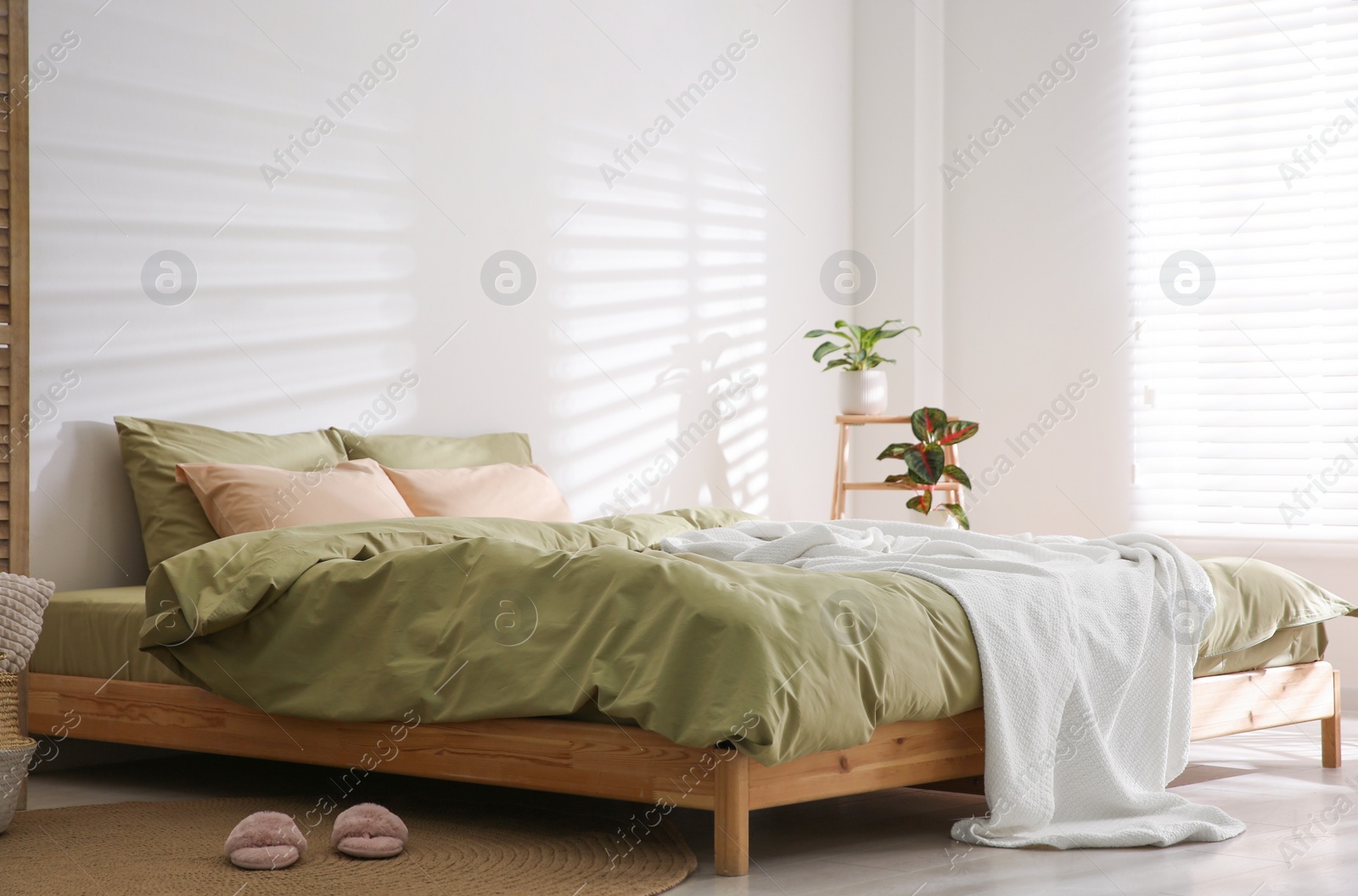 Photo of Large bed with soft blanket in stylish room interior