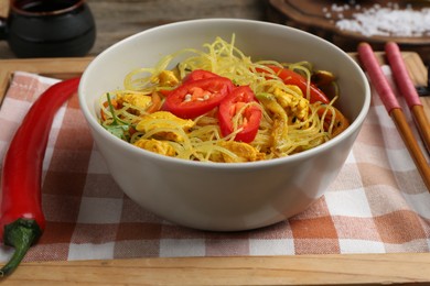 Photo of Stir-fry. Tasty noodles with vegetables and meat in bowl on table