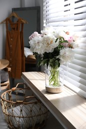 Photo of Bouquet of beautiful peony flowers on window sill indoors