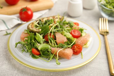 Photo of Delicious pomelo salad with grilled avocado served on light grey table, closeup
