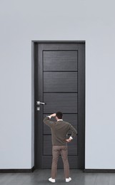 Man standing in front of door, back view