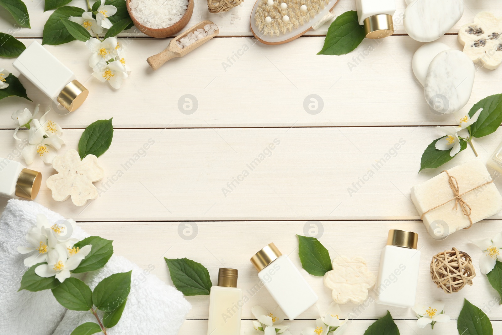 Photo of Jasmine flowers and set of spa essentials on white wooden table, flat lay. Space for text