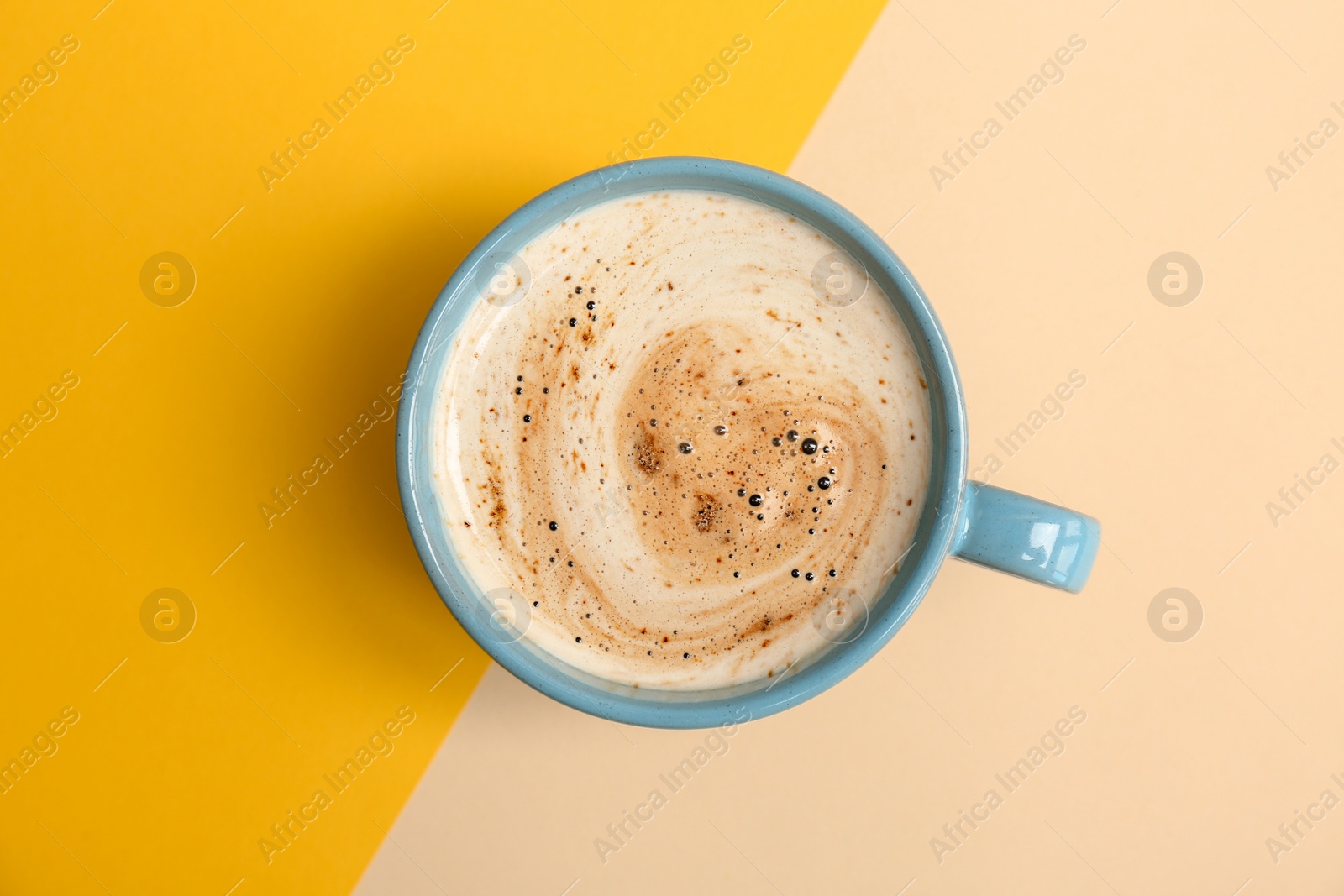 Photo of Cup of aromatic hot coffee on color background, top view