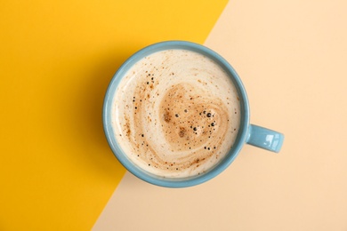 Cup of aromatic hot coffee on color background, top view