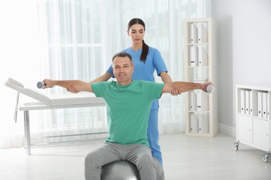 Doctor working with patient in hospital. Rehabilitation exercises