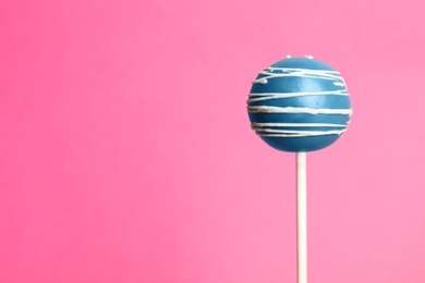 Bright delicious cake pop on color background. Space for text