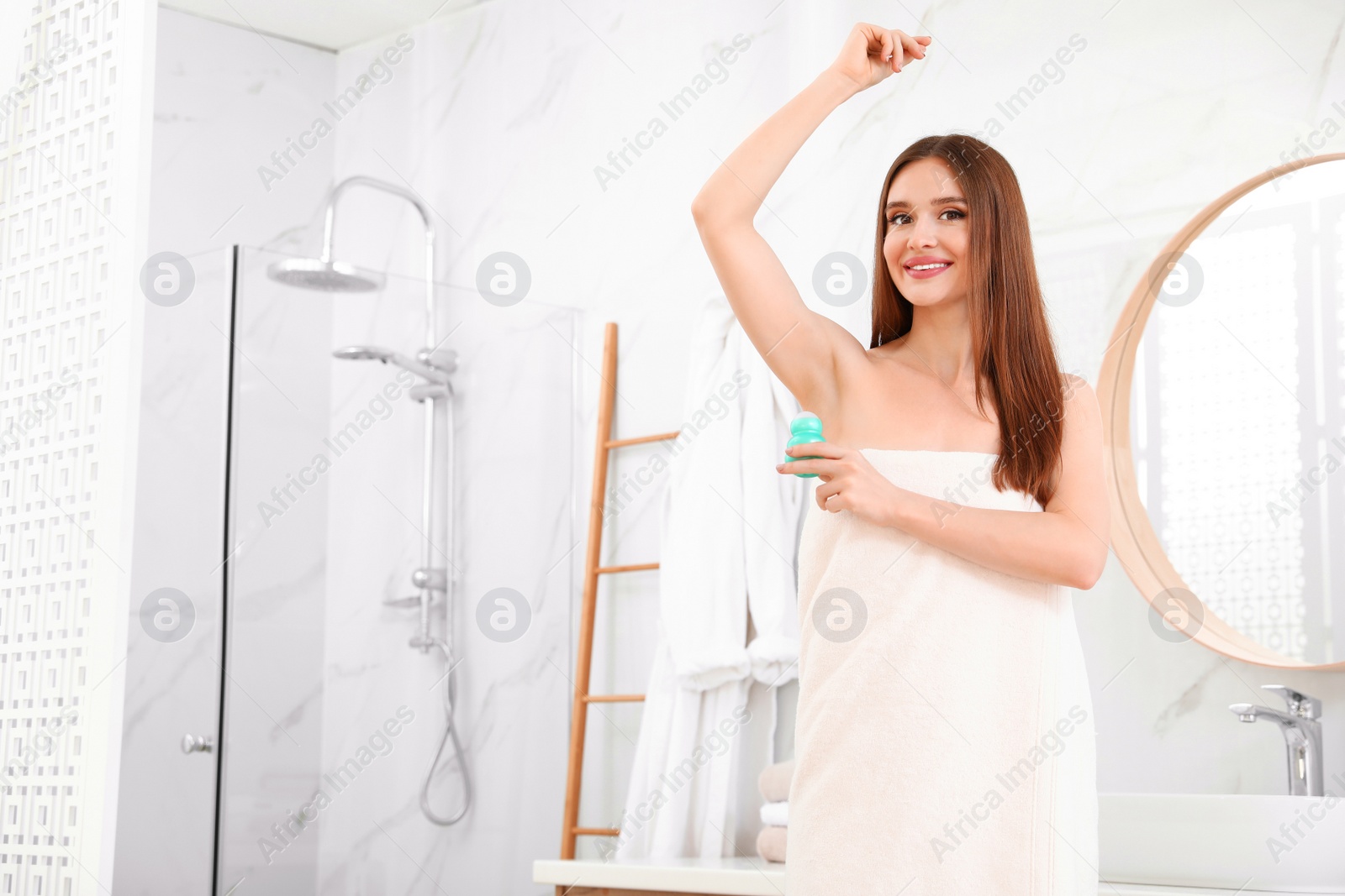 Photo of Beautiful young woman applying deodorant after shower in bathroom. Space for text