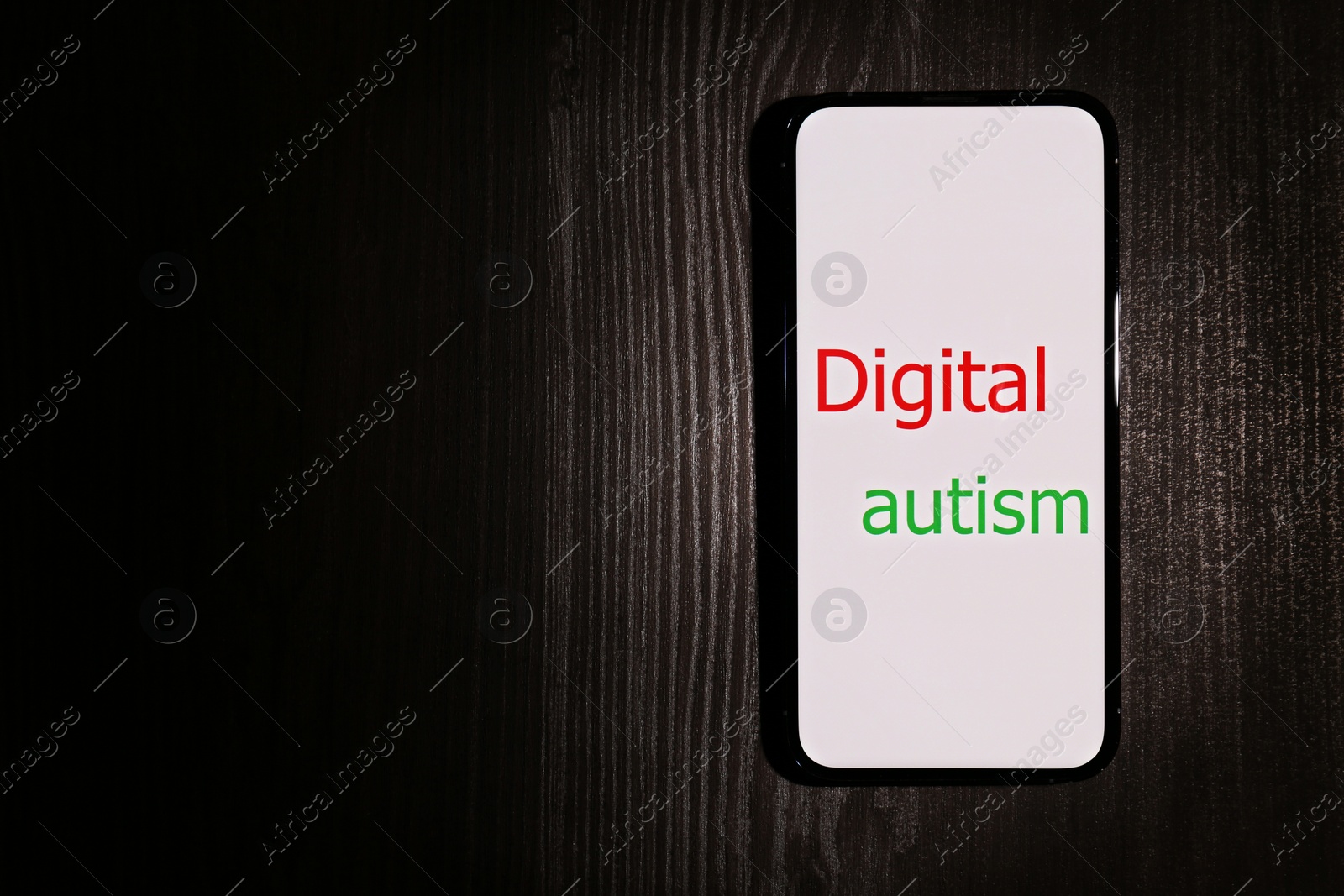 Photo of Smartphone with phrase Digital Autism on wooden table, top view and space for text. Addictive behavior