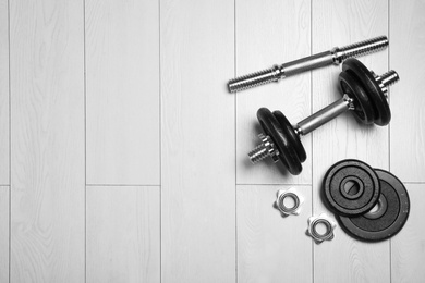 Photo of Gym equipment on wooden floor, flat lay. Space for text