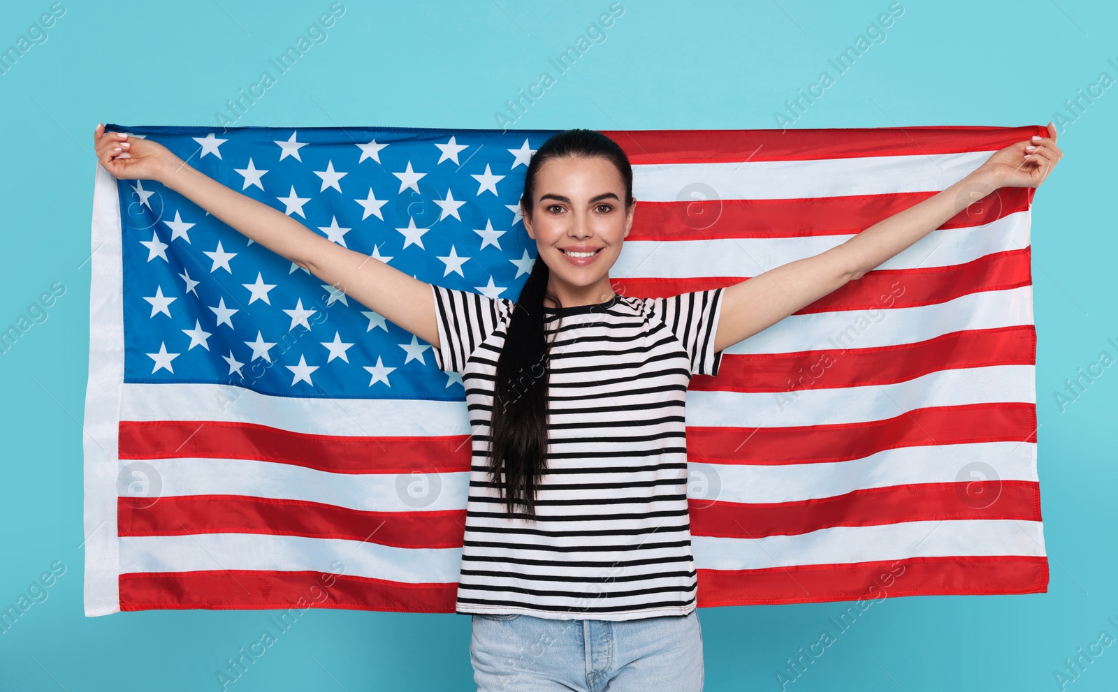 Photo of 4th of July - Independence Day of USA. Happy woman with American flag on light blue background