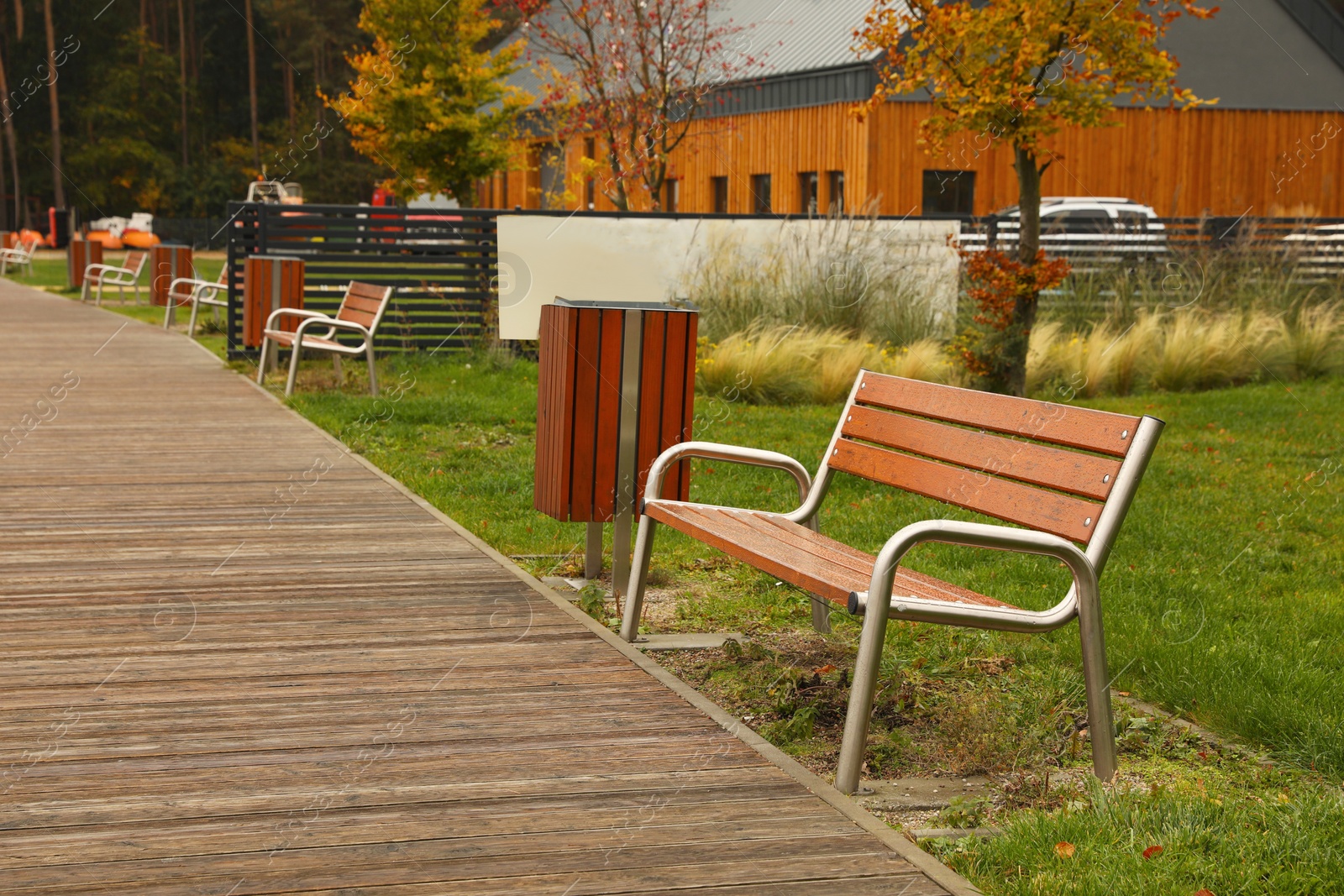 Photo of Wooden benches near pathway outdoors. Real estate