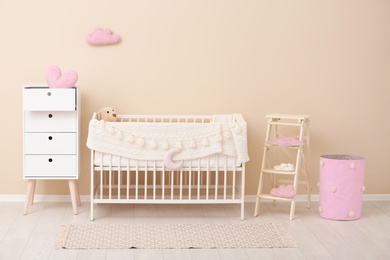 Photo of Stylish baby room interior with comfortable crib